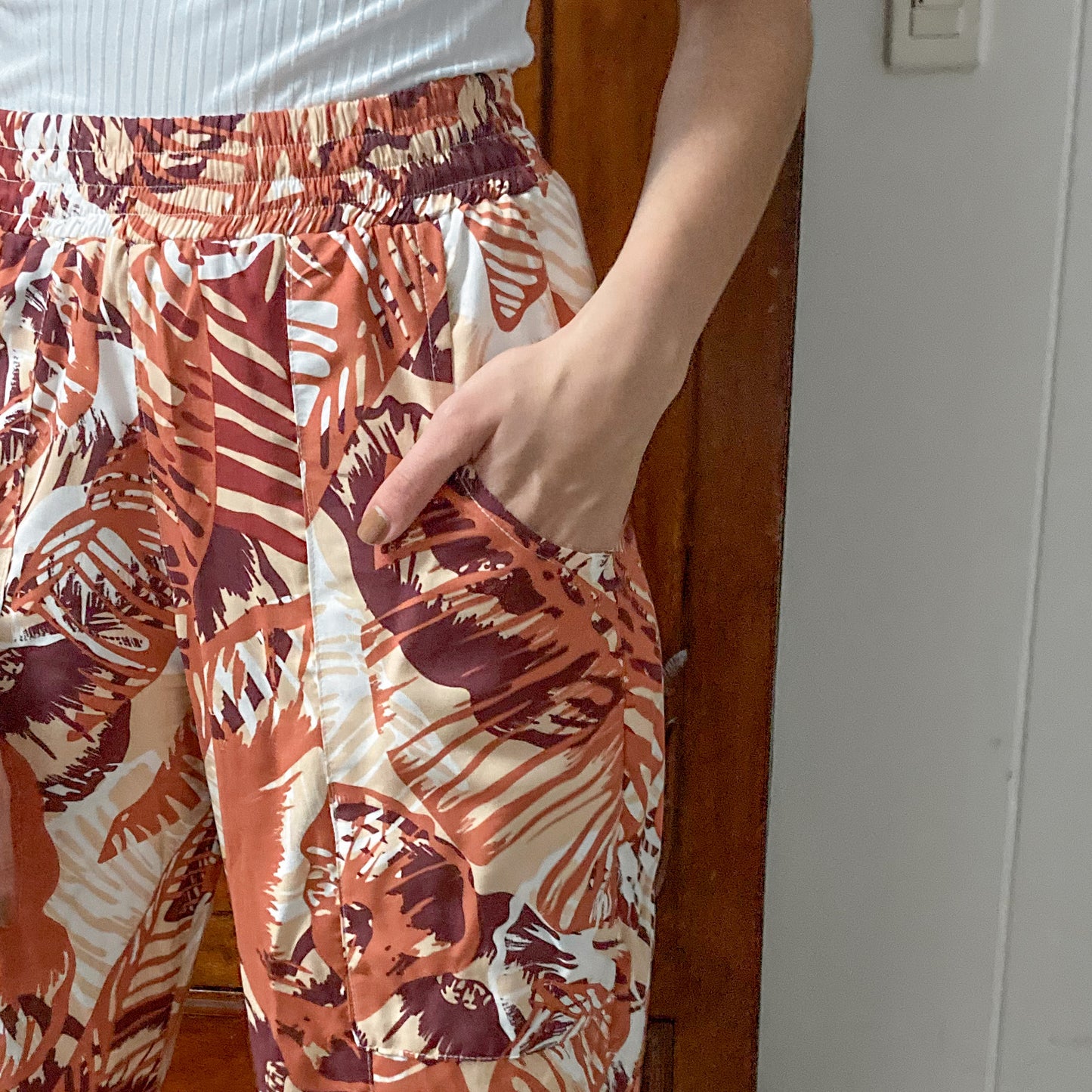 Pantalón bota recta, hecho en chalis estampado de hojas en tonos calidos, con resorte en toda la cintura y bolsillo grandes. detalles