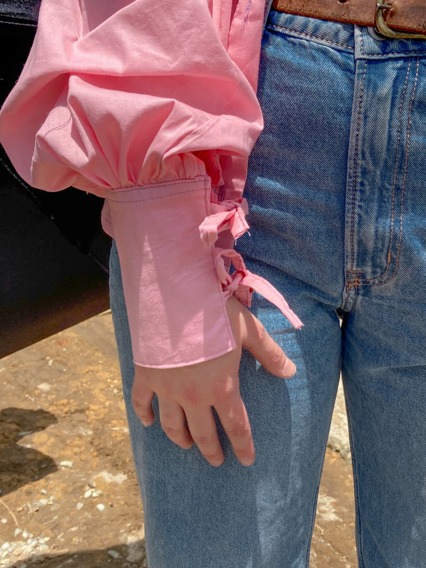 Camisa combinada rosada y estampada con mangas puff, detalles de nudos en los puños, y cuello camisero. Detalle de puño.