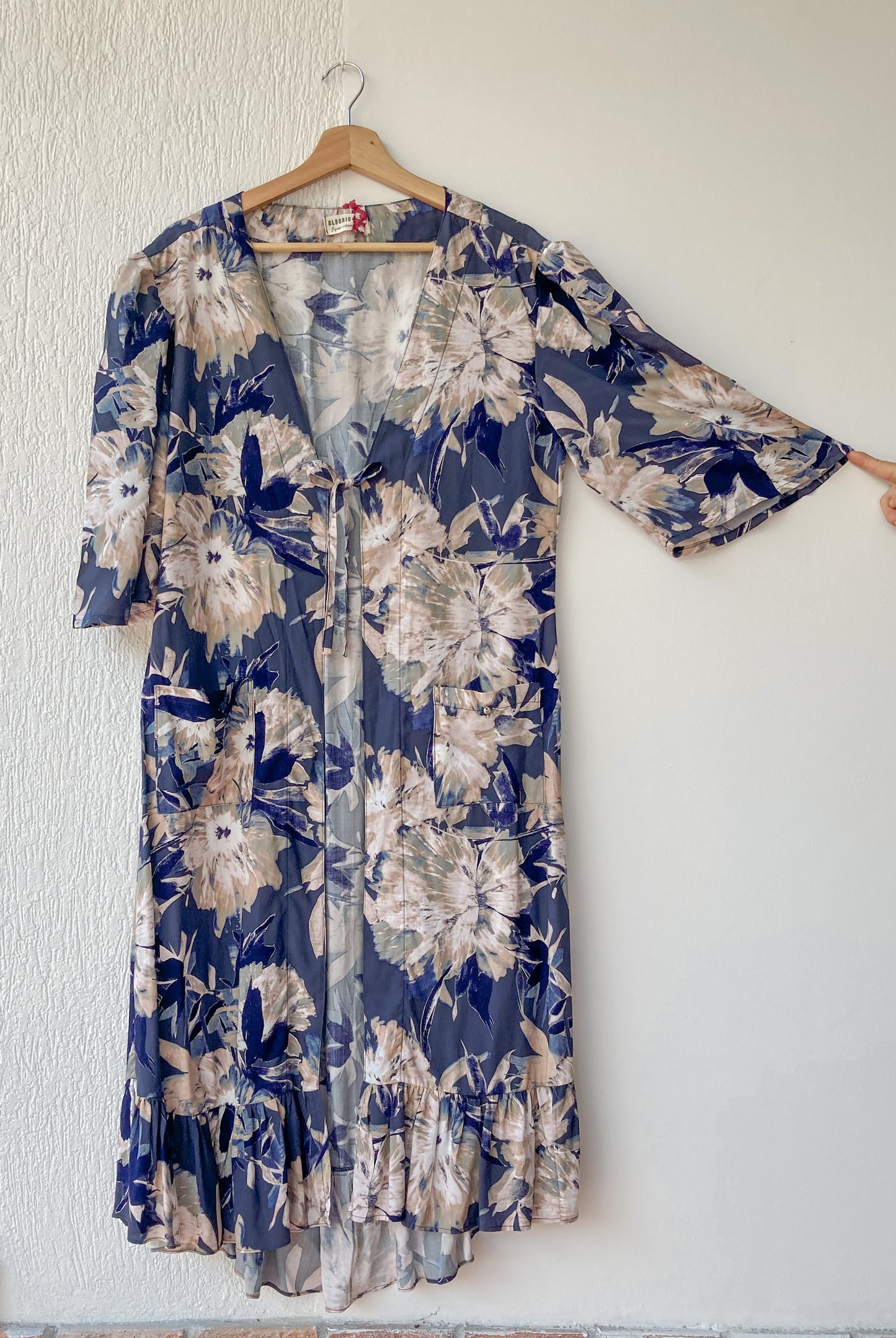 Kimono midi estampado de flores; manga corta, con bolsillos parche y detalle de amarre en el pecho; hecho 100% en Colombia por mujeres.