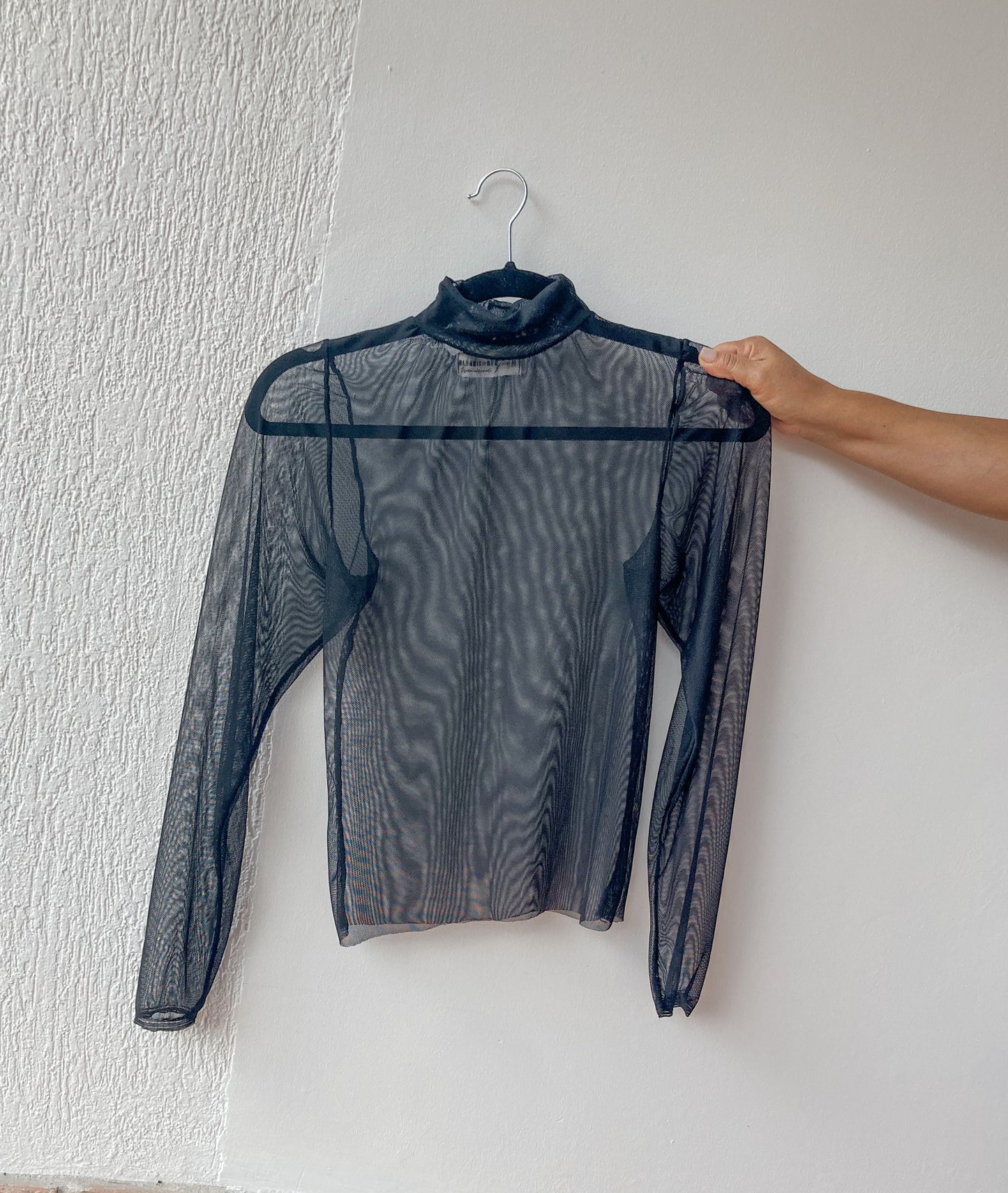 Top básico transparente con cuello alto y manga larga. color negro