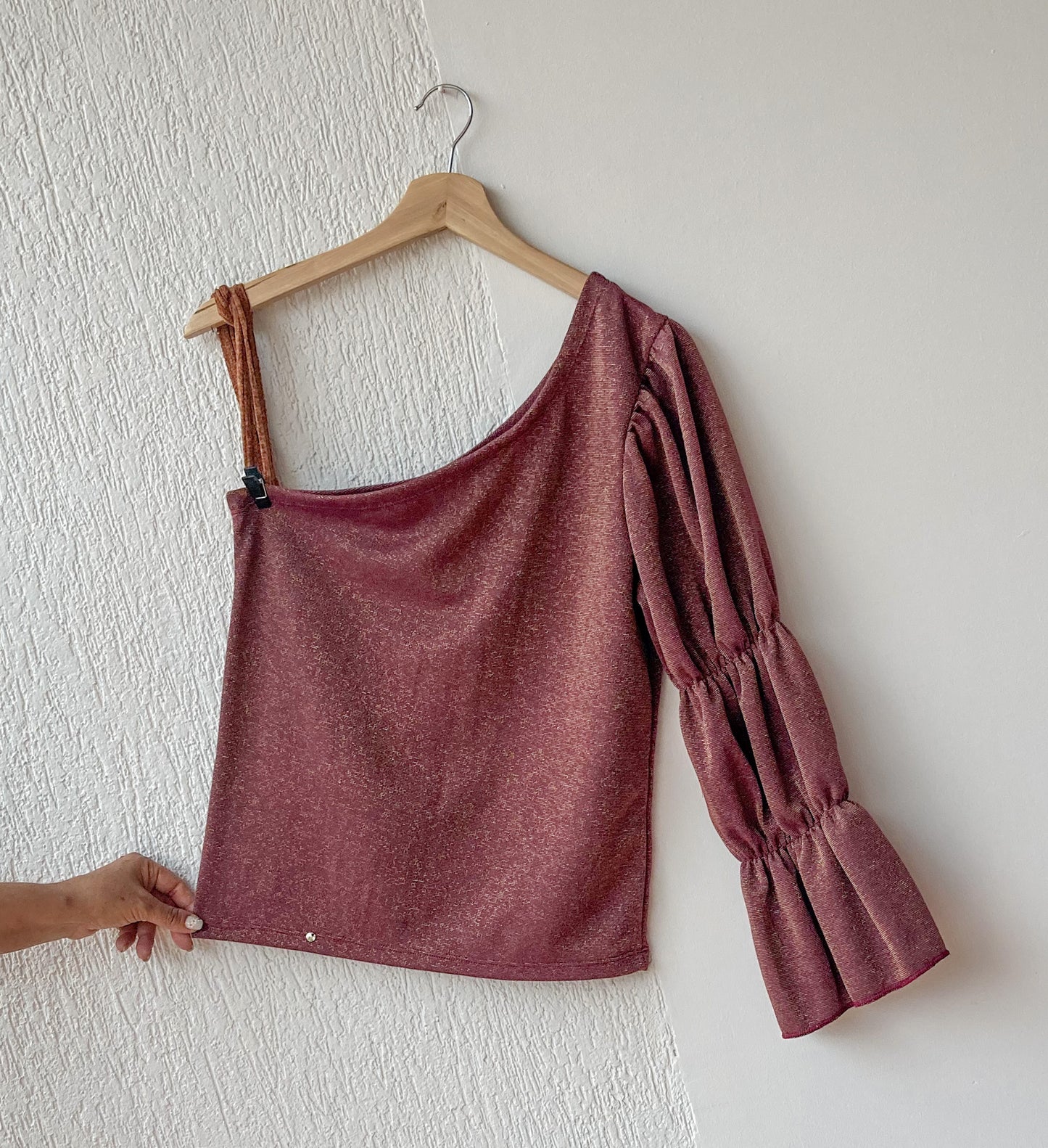Este top asimétrico, para mujer, presenta un diseño de una manga con tres resortes, además de una textura brillante que la hace única. Es ideal para cuando quieres destacar. ¡Da tu look un toque moderno con Gaia! 100% Colombiana, producto local.