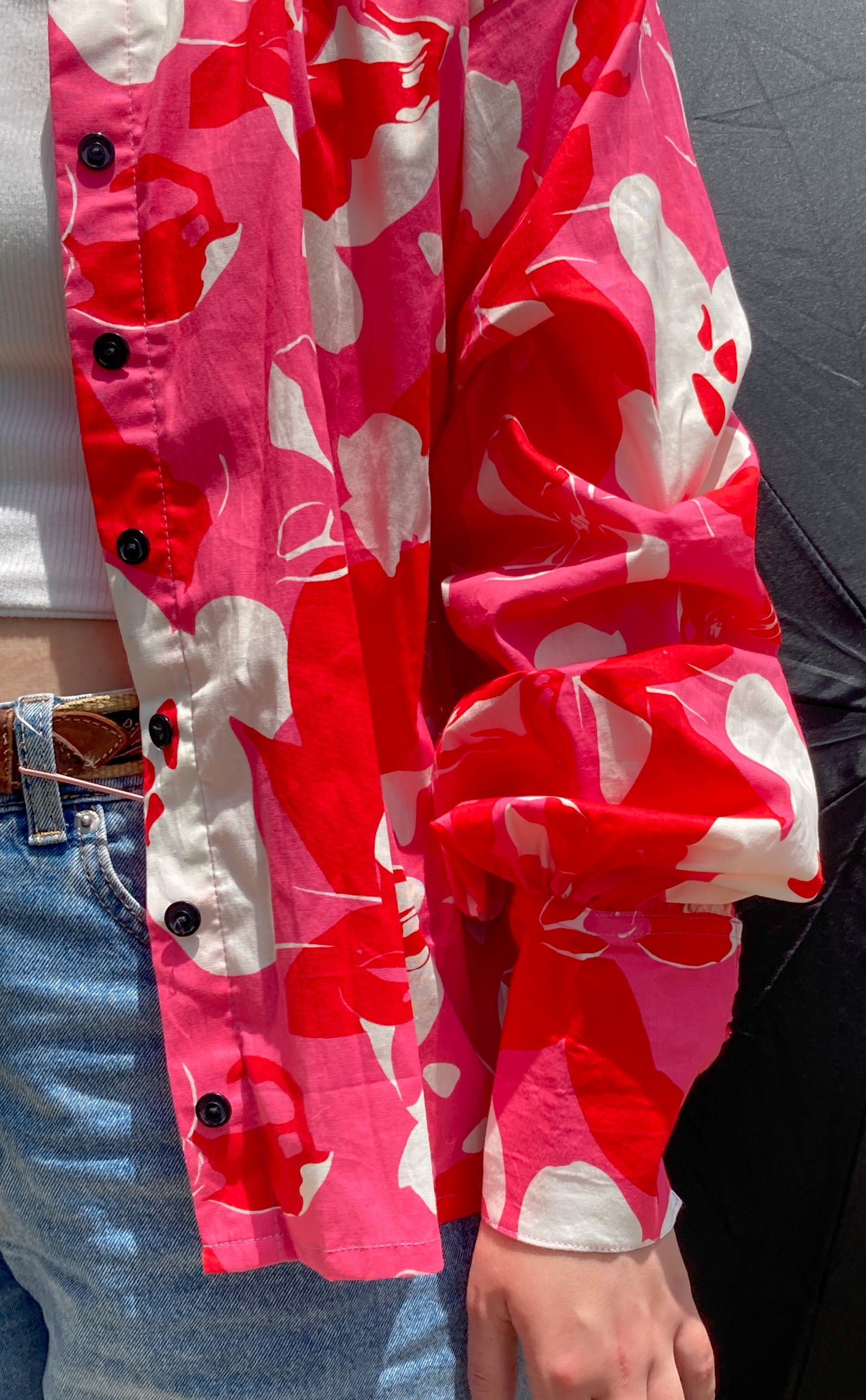 Camisa combinada rosada y estampada con mangas puff, detalles de nudos en los puños, y cuello camisero. detalle de manga y estampado.