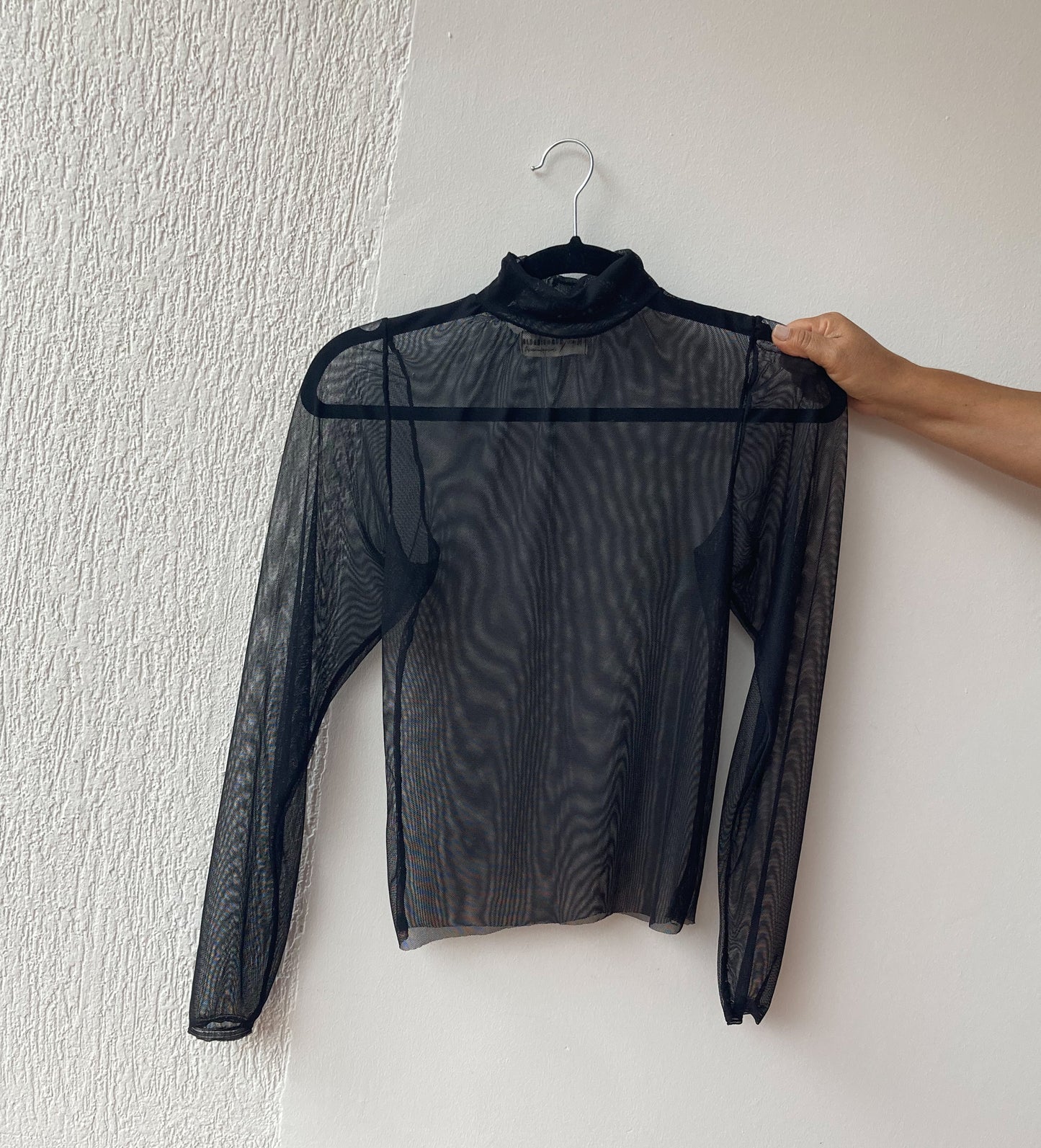 Top básico transparente con cuello alto y manga larga. color negro