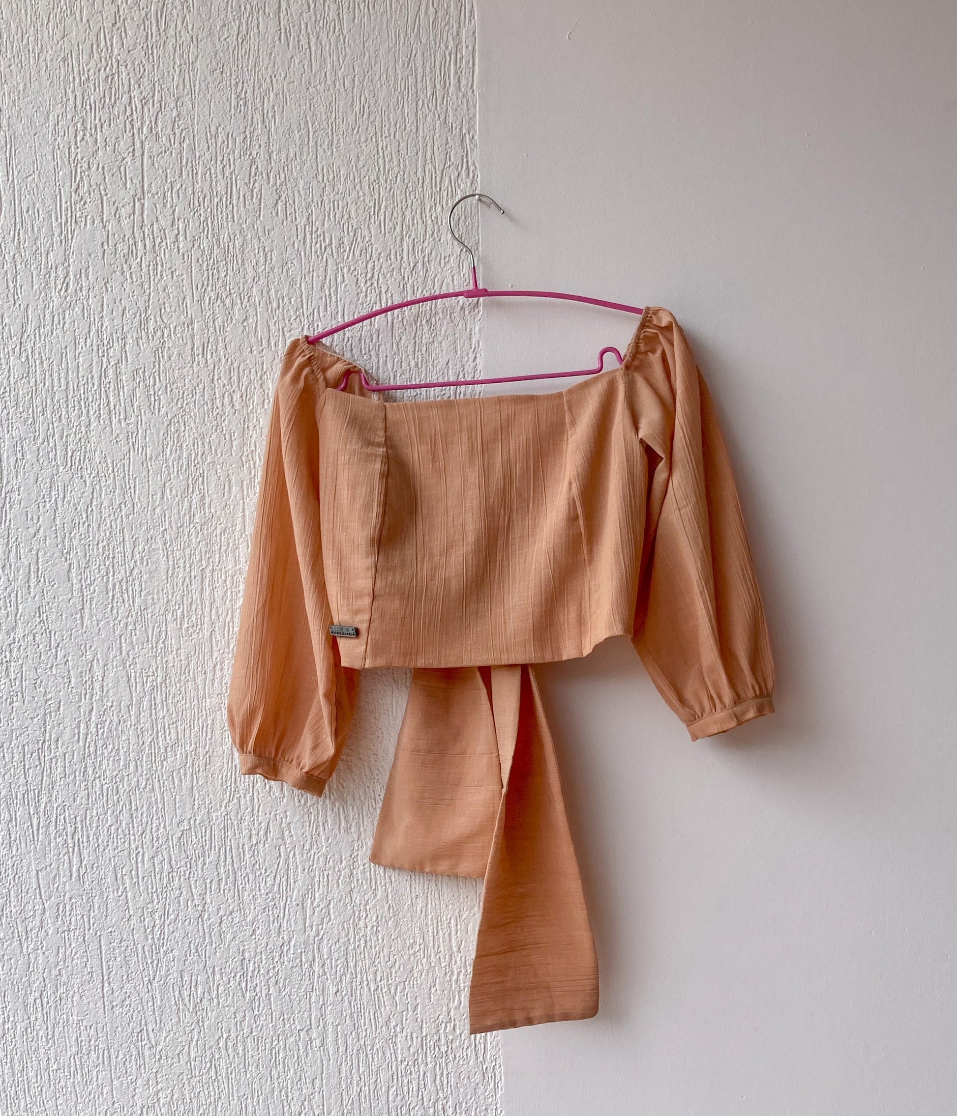 Esta blusa es un crop top que tiene un escote cuadrado y un nudo que se puede atar por delante o por detrás. Es una prenda versátil y cómoda que se adapta a diferentes estilos.  100% Colombiano, producto local.