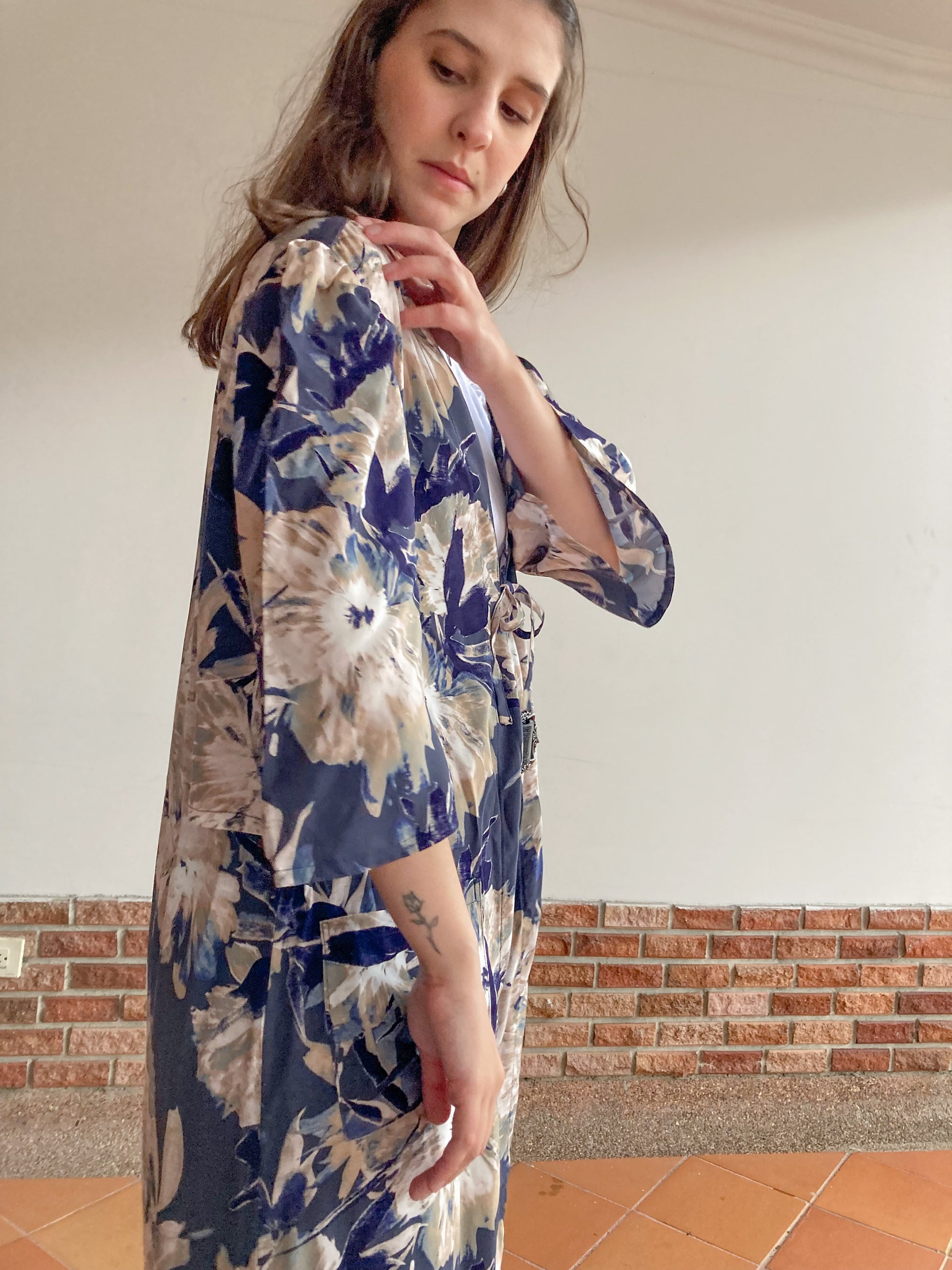 Kimono midi estampado de flores; manga corta, con bolsillos parche y detalle de amarre en el pecho; hecho 100% en Colombia por mujeres.